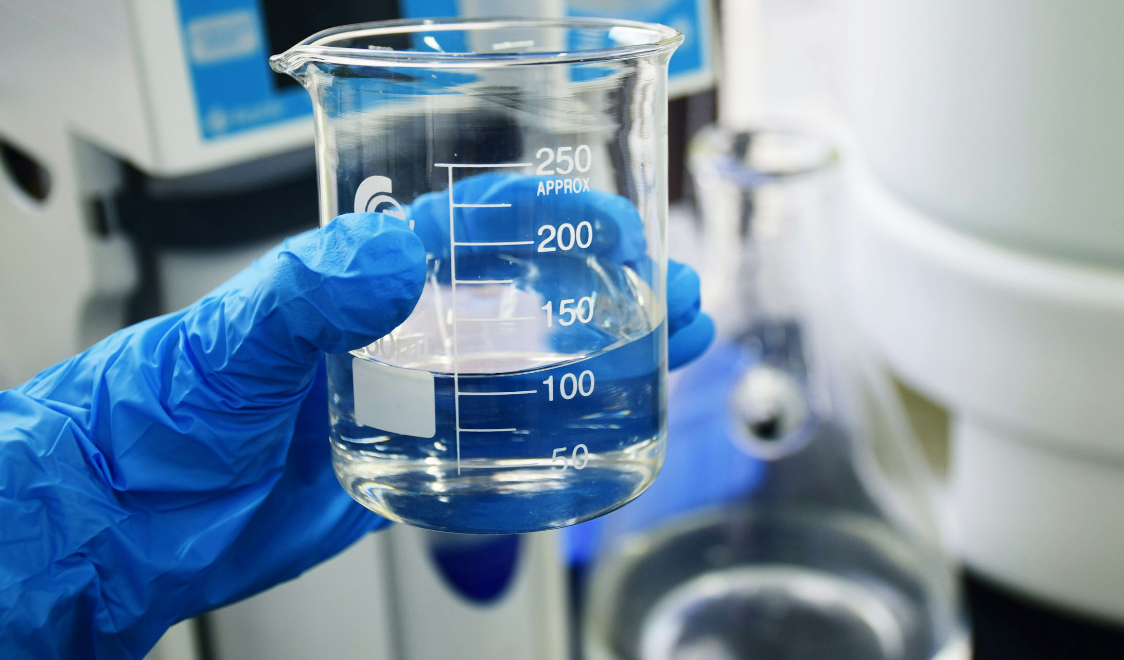 Water quality testing: Person holding a measuring glass with water Water quality testing: Person holding a measuring glass with water